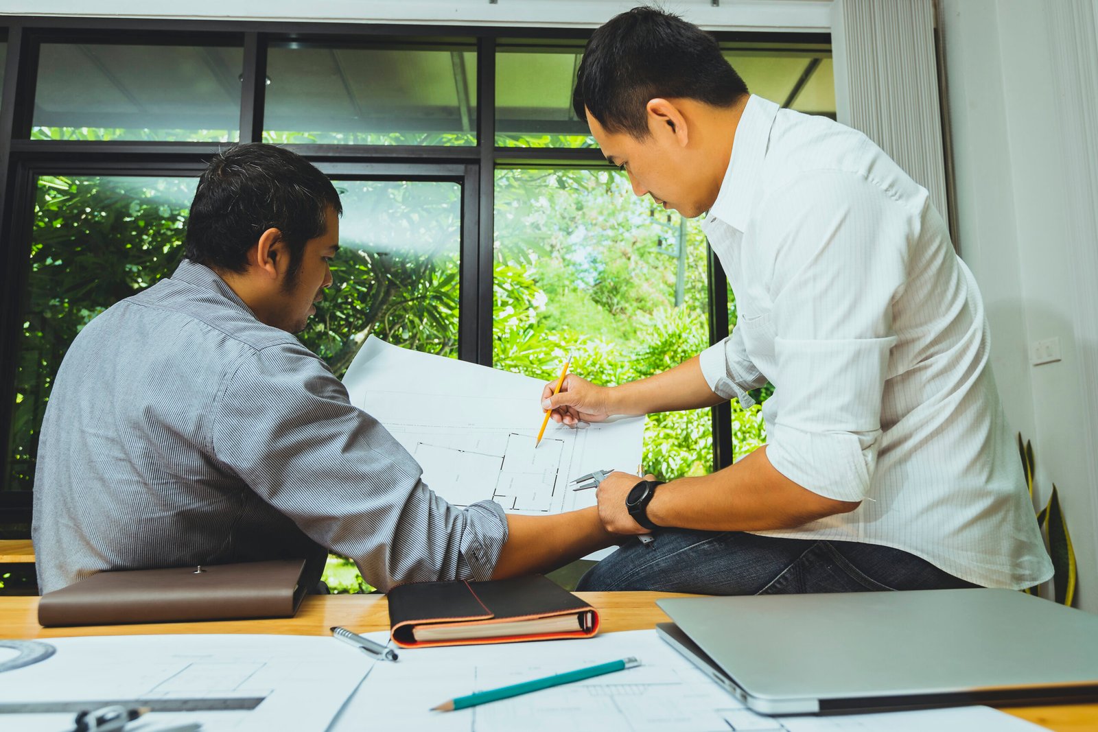 Confident team of architect working together in a office.They discussing about new startup project on desk. Architect discuss with engineer about project in office, architectural concept