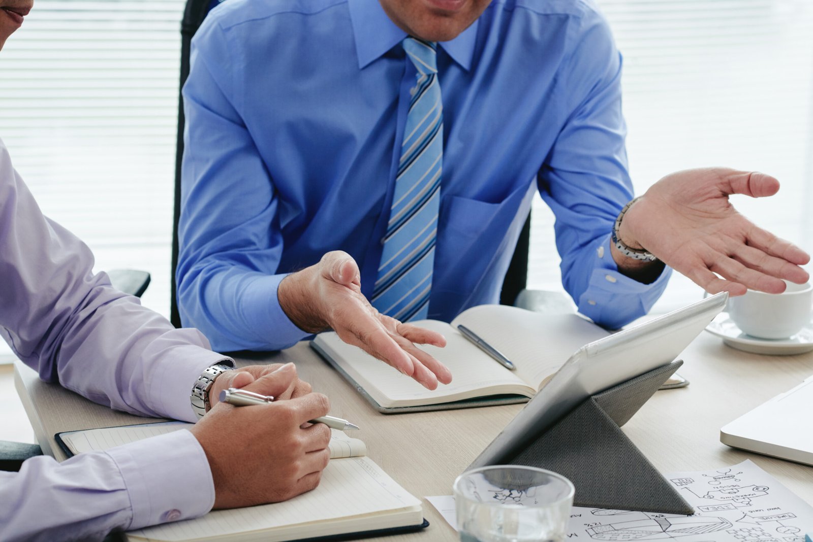 Cropped image of business people dicussing information on digital tablet