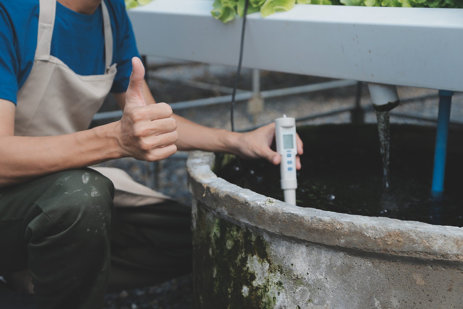 View of an attractive farmer in a greenhouse using tablet